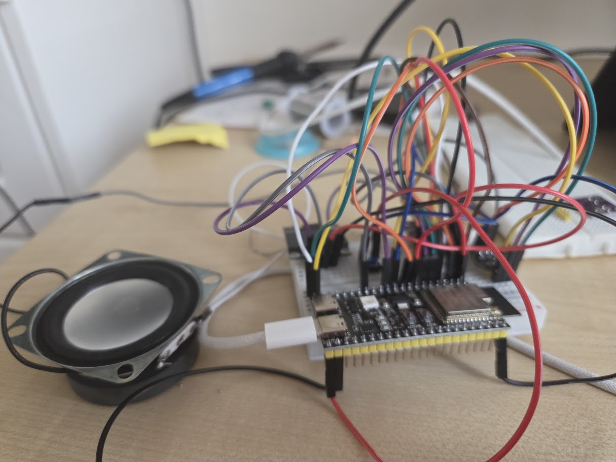 Early hardware prototype — ESP32 board, microphone, speaker and breadboard wiring on a desk